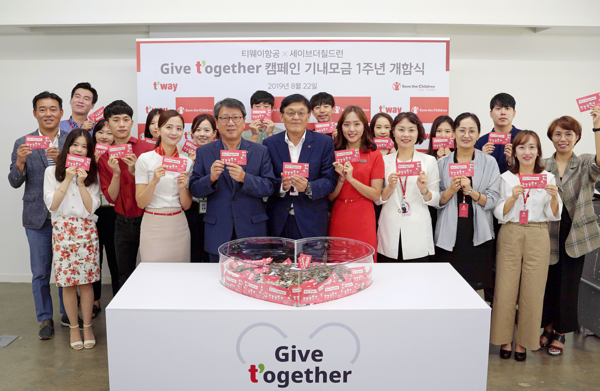 ▲8월22일 오후 서울 마포구 세이브더칠드런 사옥에서 정홍근 티웨이항공 대표(가운데 좌측), 김태영 세이브더칠드런 사무총장(가운데 우측) 및 관계자들이 참석한 가운데 기내 모금 ‘Give t’ogether (기브투게더)’ 캠페인 1주년 기념 개함식 행사를 진행하고 있다. (자료제공=티웨이항공)