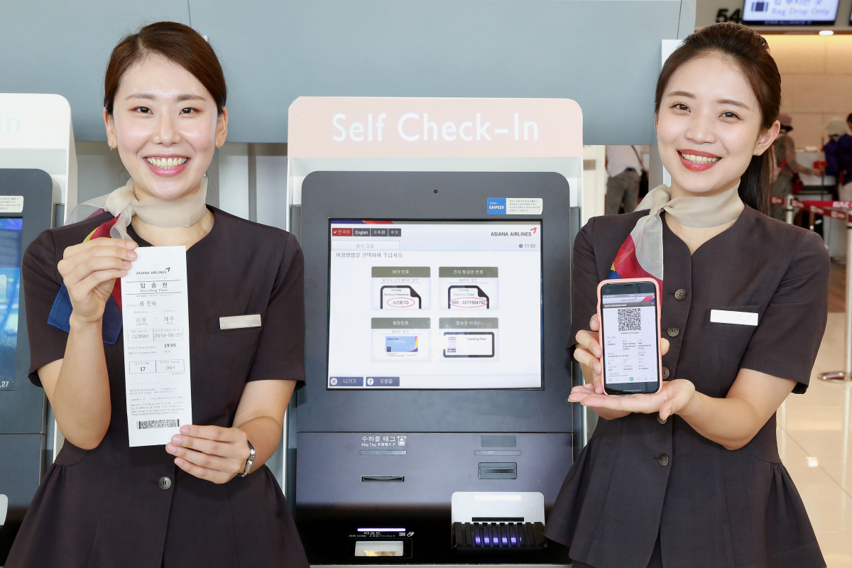 ▲아시아나항공 공항 서비스 직원이 김포공항 국내선 터미널에서 셀프체크인 키오스크 탑승권과 모바일 탑승권을 들어보이고 있다. (자료제공=아시아나항공)