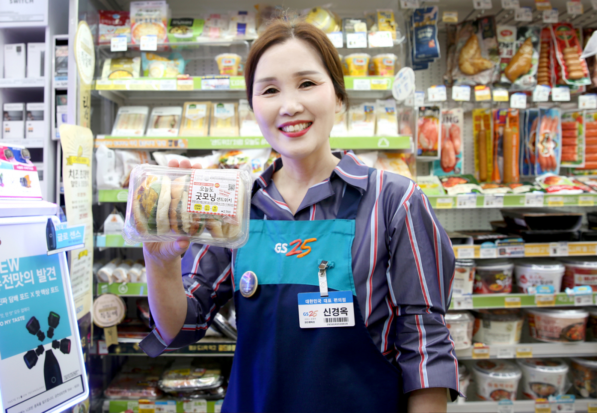 ▲GS25의 신경옥 경영주가 기획한 오늘도굿모닝샌드위치를 들고 포즈를 취하고 있다.(GS리테일 제공)