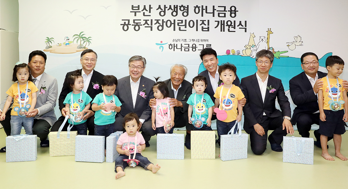 ▲박승 하나금융 사회공헌위원회 위원장(왼쪽에서 네번째)과 함영주 하나금융 부회장(왼쪽에서 다섯번째)이 28일 부산광역시 연제구 연산동지점 2층에서 열린 ‘상생형 공동직장 어린이집 개원식’에 참석해 기념촬영을 하고 있다.(사진제공=하나금융)