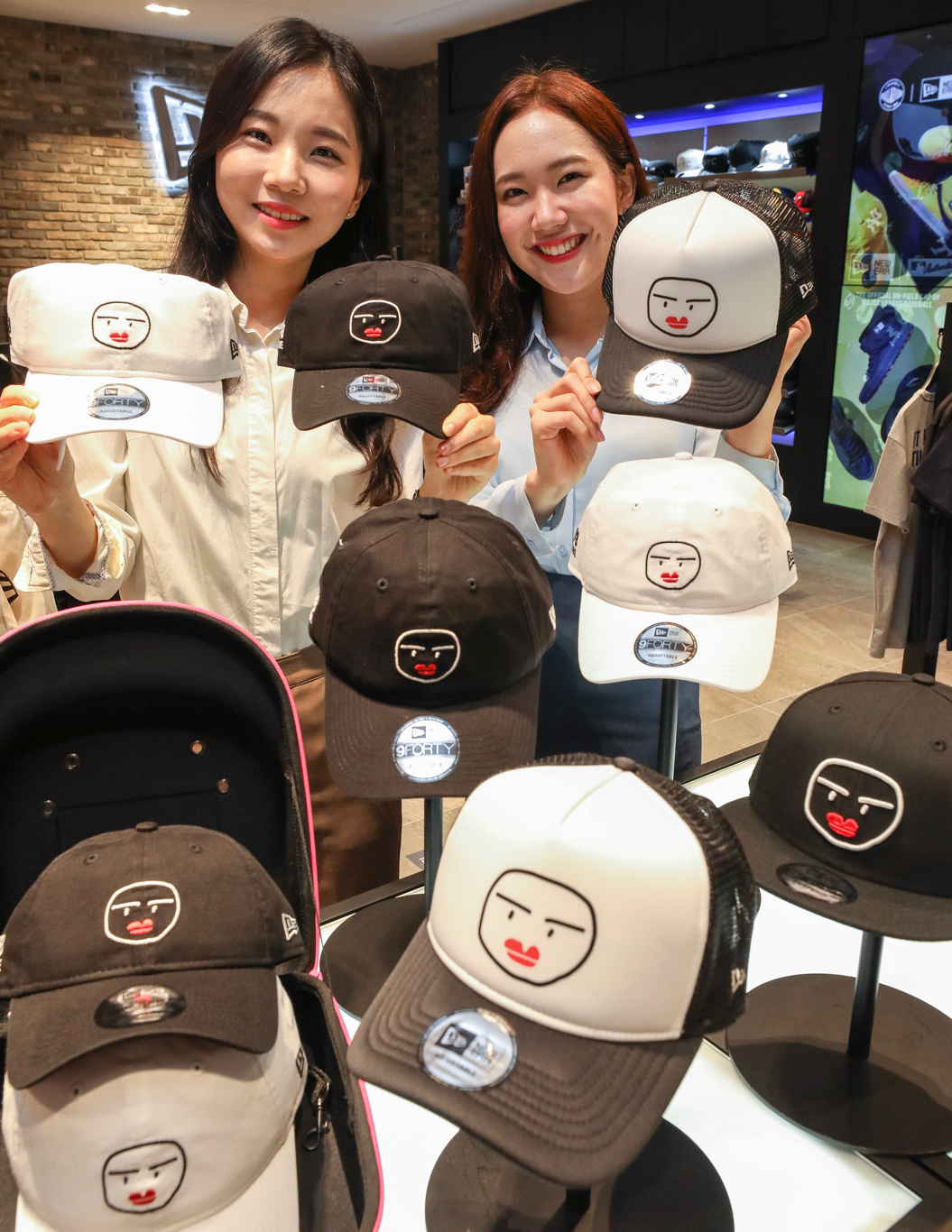 ▲29일 오전 현대백화점 판교점 5층 뉴에라 매장에서 직원들이 김재원의 캐릭터인 '재일이'가 모자 전면에 프린팅 된 볼캡 모자와 스냅백을 선보이고 있다. (사진제공=현대백화점)