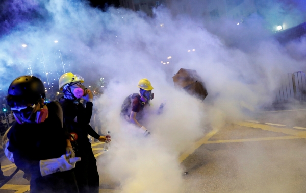▲홍콩 웡타이신에서 4일 새벽 송환법 반대 시위자들이 경찰이 발사한 최루탄에 휩싸여 고통스러워하고 있다. 웡타이신/로이터연합뉴스
