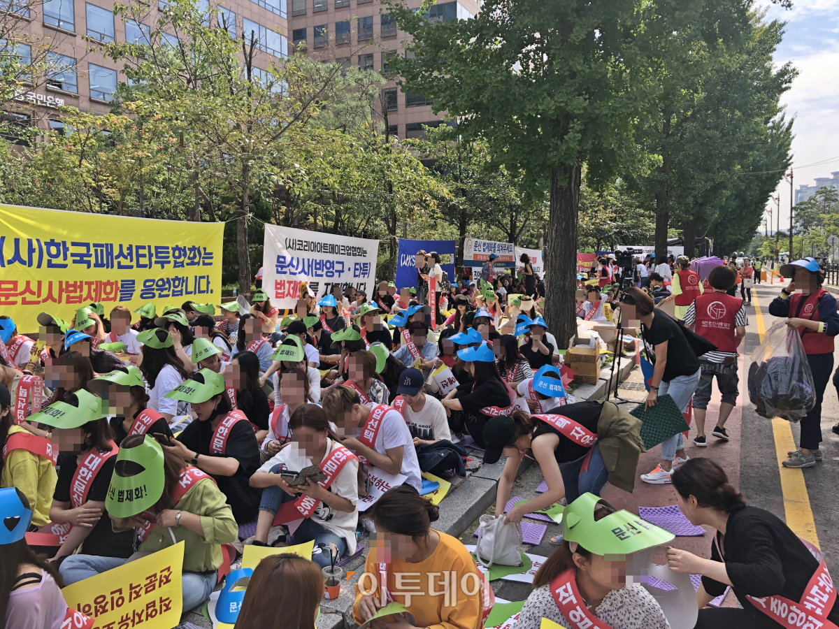 ▲전국에서 모인 문신사들이 국회 앞에 모였다. 이들은 햇빛을 가리기 위한 색색의 종이모자를 쓰고 있었다. (홍인석 기자 mystic@)