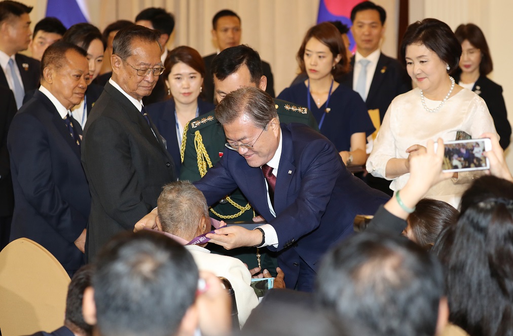 ▲문재인 대통령과 김정숙 여사가 2일 방콕 총리실 청사에서 한국전 참전 용사인 전 태국 육군 대령 아폰 우타까녹에게 '평화의 사도 메달'을 전달하고 있다.(방콕/연합뉴스)