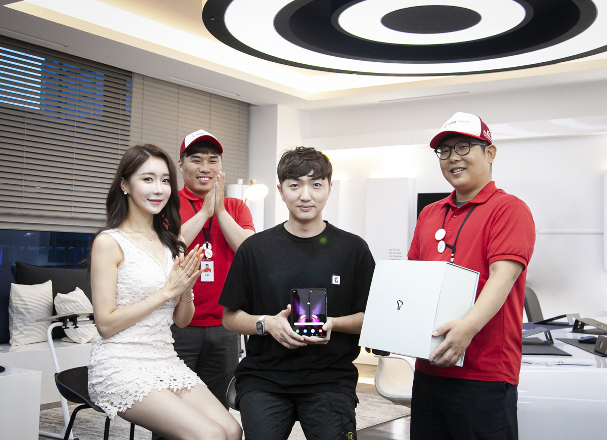 ▲갤럭시 폴드 5G 행운의 고객 안진우씨가 ‘오늘도착’ 라이더로부터 단말을 배송받는 모습(사진제공= SK텔레콤)