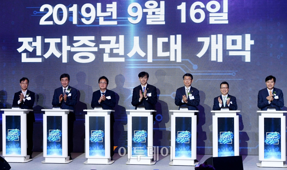 ▲조국 법무부 장관과 은성수 금융위원장, 민병두 국회 정무위원장 등이 16일 서울 여의도 콘래드 호텔에서 열린 전자증권제도 시행 기념식에서 종이증권을 세절기에 넣는 퍼포먼스를 마친 뒤 박수를 치고 있다. (신태현 기자 holjjak@)