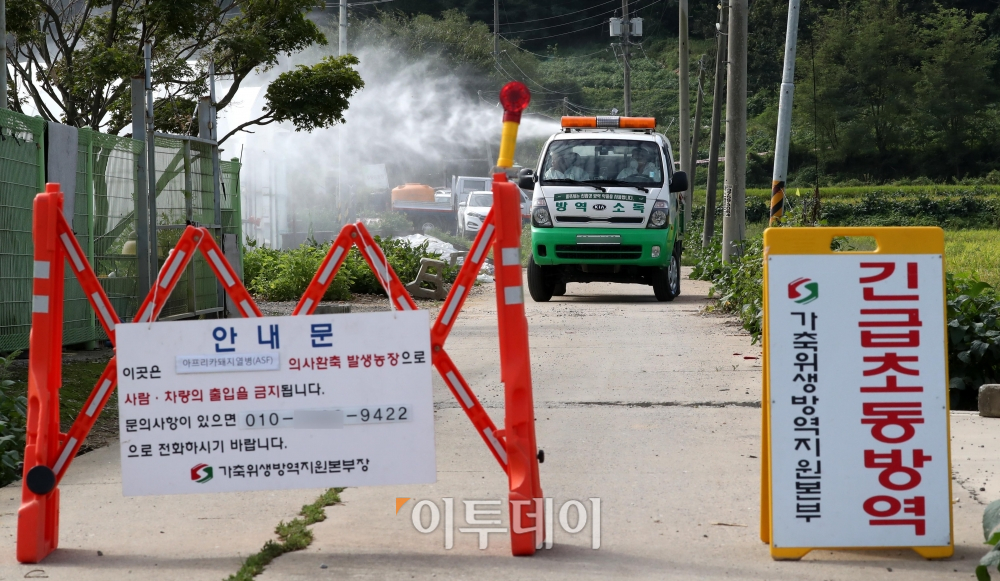 ▲지난 17일 방역당국이 경기도 파주시의 한 양돈농장 입구에서 출입을 통제한 채 방역작업을 하고 있다.(신태현 기자 holjjak@)