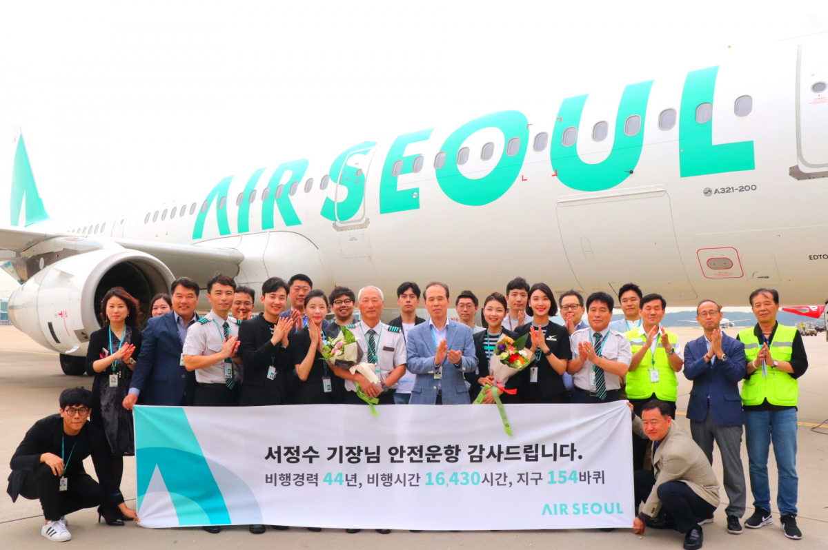 ▲에어서울 서정수 기장이 마지막 비행을 마치고 임직원들과 기념 촬영을 하고 있다. (자료제공=에어서울)