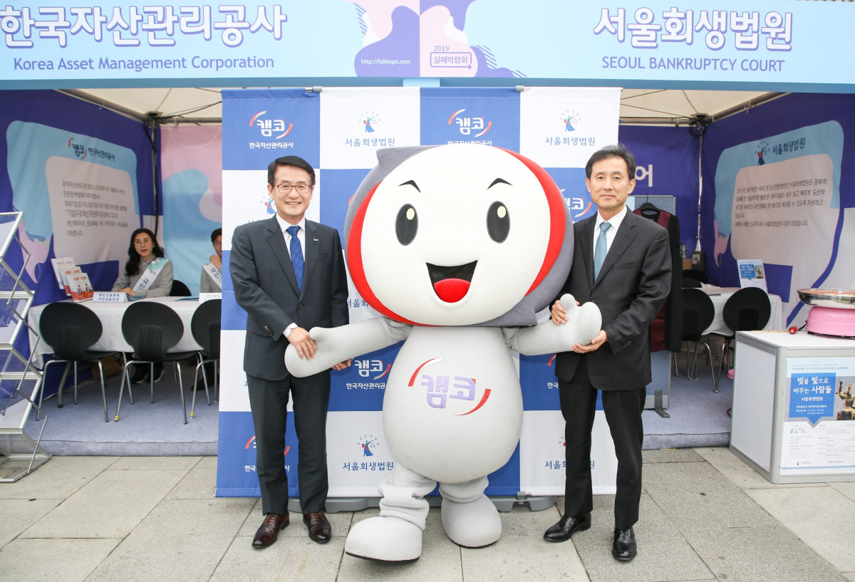 ▲문창용(왼쪽) 캠코 사장과 서경환 서울회생법원 수석부장판사가 20일 서울 광화문 광장 ‘2019 실패박람회’ 현장상담 부스에서 기념촬영을 하고 있다.(사진제공=캠코)