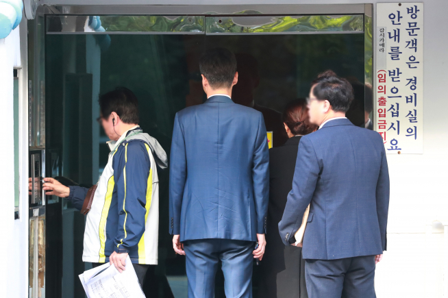 ▲검찰 수사관들이 23일 오전 서울 서초구 방배동 조국 법무부 장관 자택 압수수색을 하기 위해 아파트 현관으로 들어서고 있다.(뉴시스)