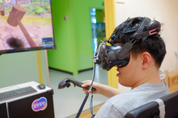 ▲연세대 재활학교 학생이 VR 인지훈련 콘텐츠를 체험하고 있다. (출처=한컴지엠디)
