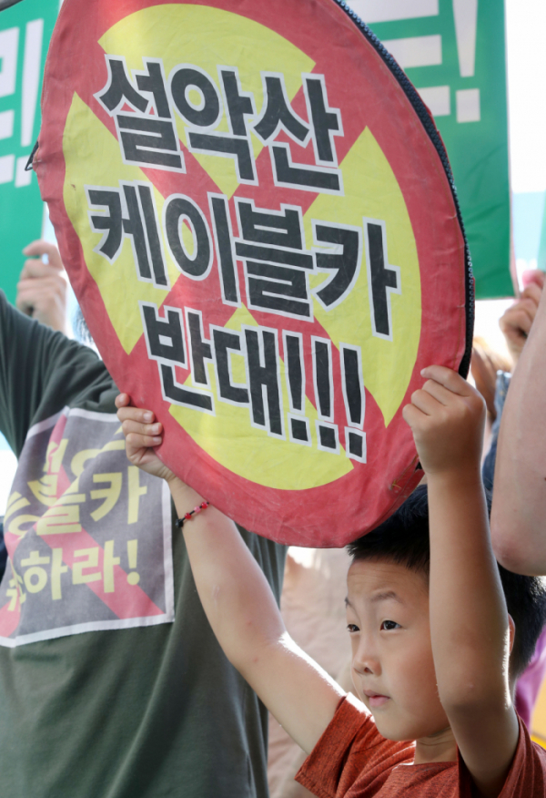 ▲환경부가 설악산케이블카사업 환경영향평가서에 대해 최종적으로 부동의 결정을 내린 16일 오후 서울 용산구 서울스퀘어 앞에서 열린 환경부 설악산케이블카 부동의 결정 환영 기자회견에서 한 어린이가 '설악산케이블카 반대'란 문구가 적힌 손피켓을 들고 있다. (뉴시스)