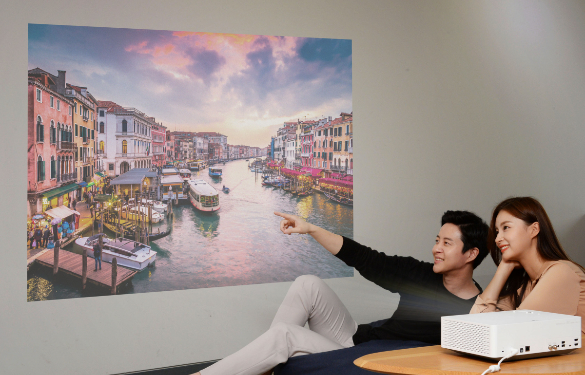 ▲서울 여의도 LG트윈타워에서 모델들이 'LG 시네빔 4K' 프로젝터가 구현하는 초대형 화면으로 영상을 즐기고 있다.(사진제공=LG전자)