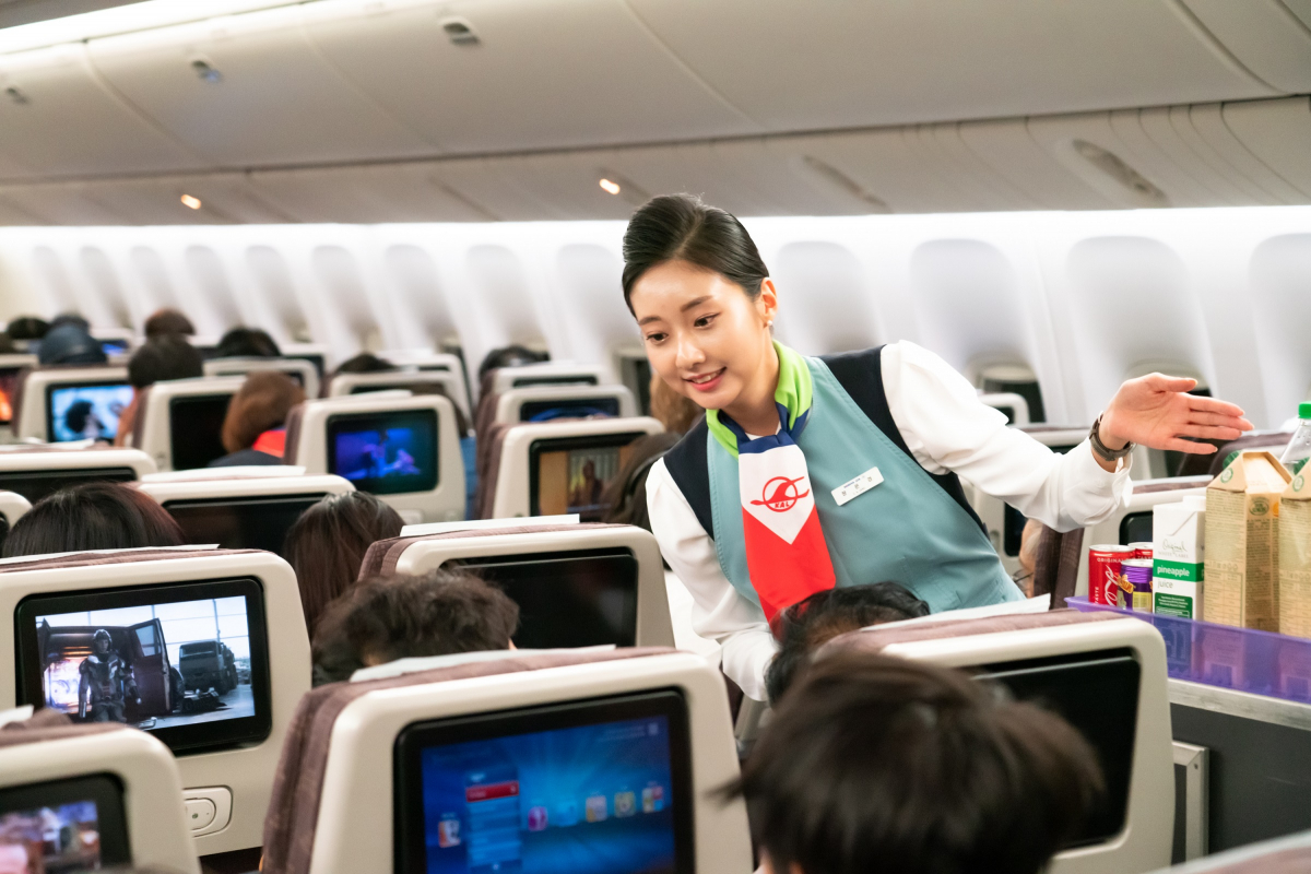 ▲창사 50주년 기념 항공기인 KE683편에서 객실승무원들이 역대 유니폼을 입고 기내 서비스를 하는 모습. (사진제공=대한항공)