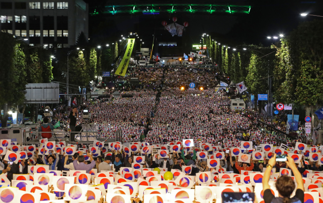 ▲5일 오후 서울 서초구 서초역 사거리에서 열린 '제8차 검찰개혁 촛불 문화제'에서 참석자들이 태극기 손팻말을 흔들며 구호를 외치고 있다.(연합뉴스)