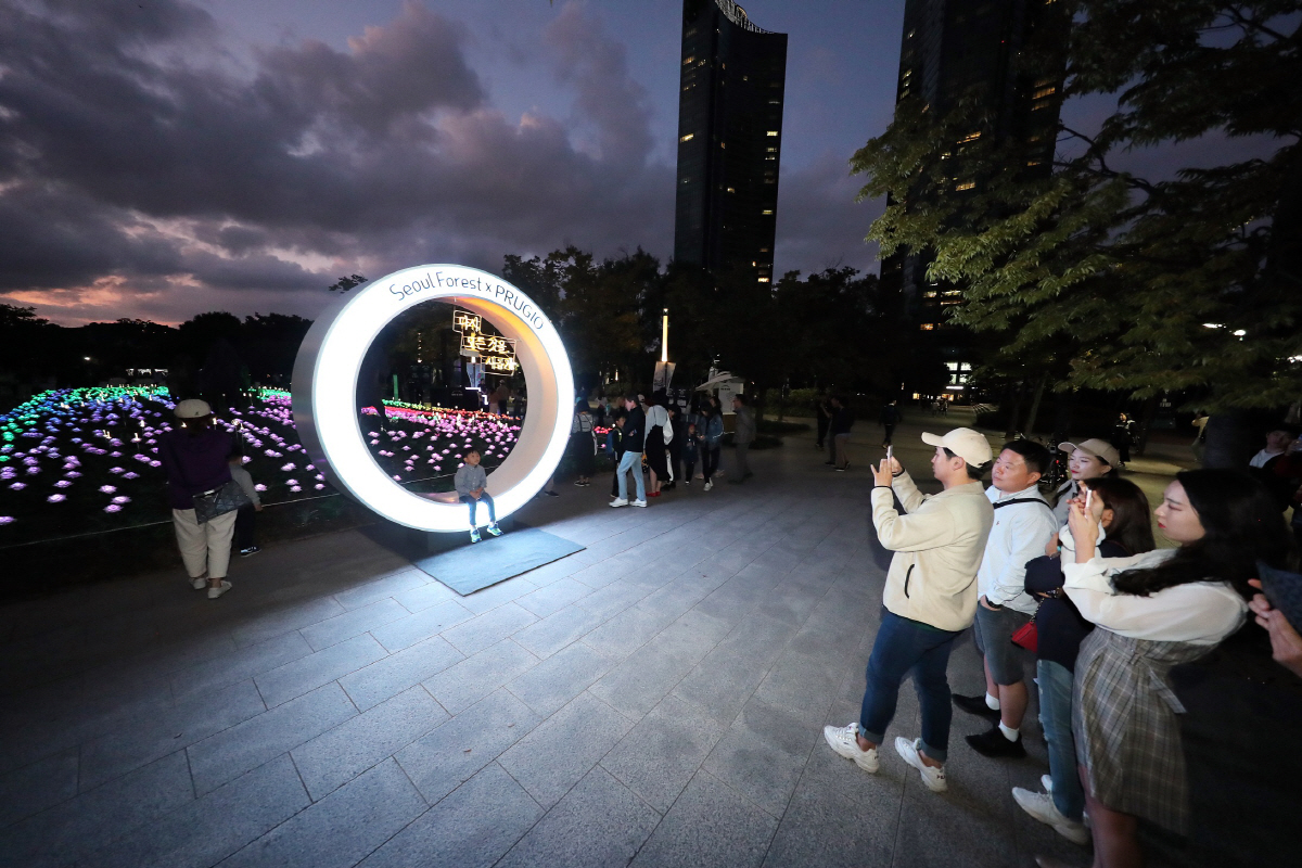 ▲지난 5일 서울 성동구 서울숲에서 시작된 ‘푸르지오 장미 빛 정원’ 행사 포토존에서 시민들이 사진 촬영을 하고 있다.(사진 제공=대우건설)