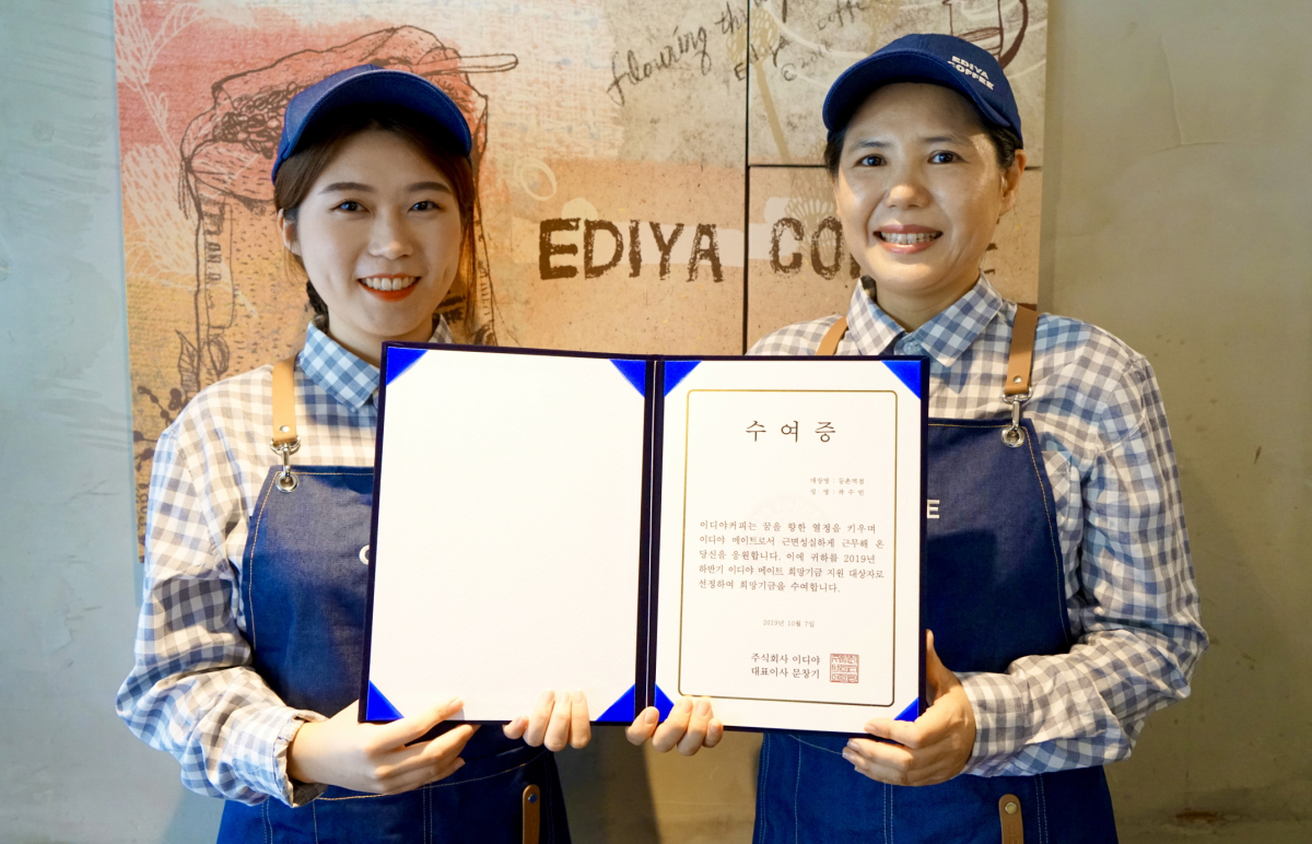 ▲8일 이디야커피 등촌역점에서 이디야 메이트 곽수빈양(사진 왼쪽)이 이디야 메이트 희망기금을 전달받고 점주와 사진 촬영을 하고 있다.(사진제공=이디야커피)