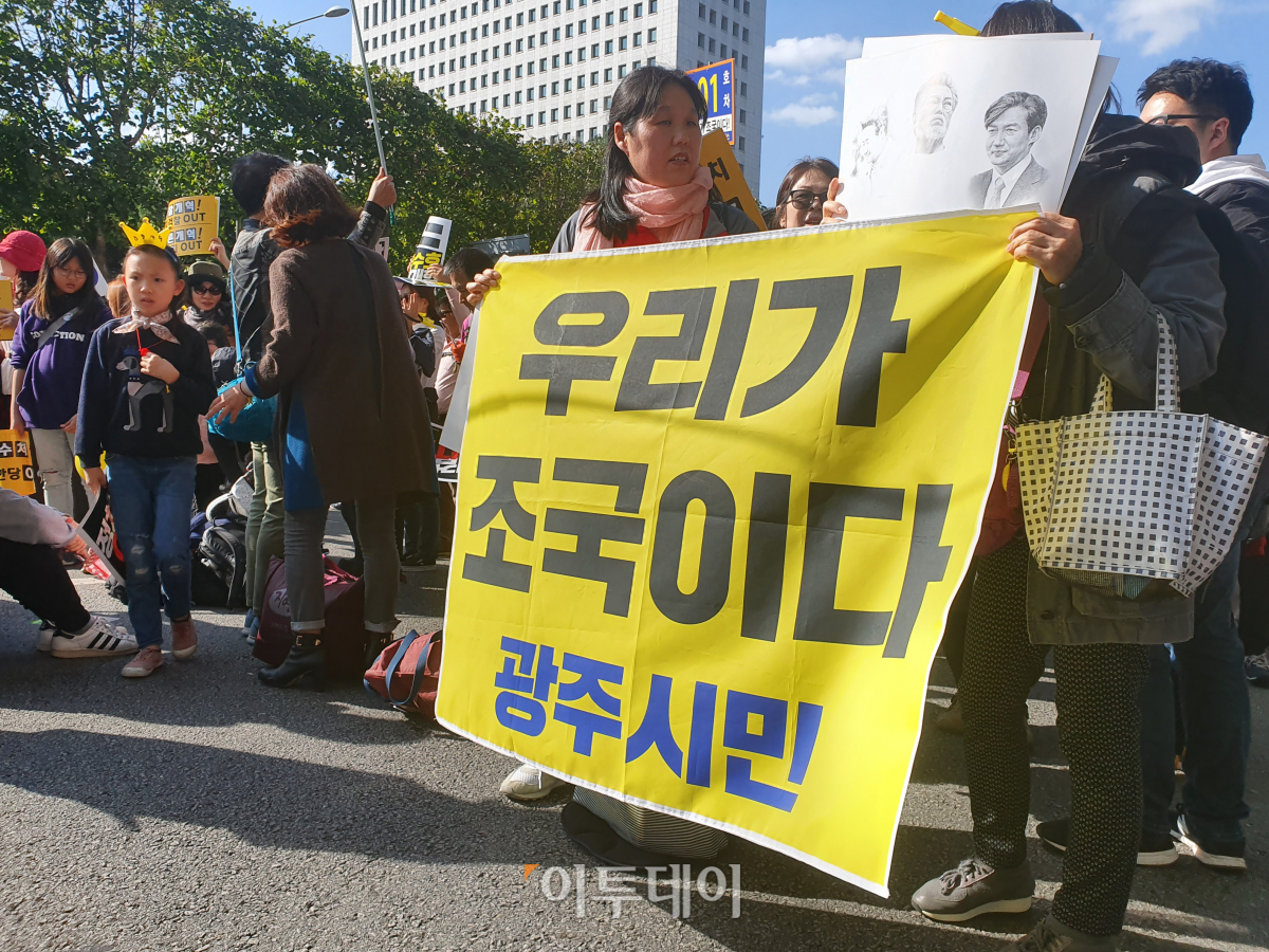 ▲12일 서울 서초구 서초동에서 열린 '제9차 사법적폐 청산을 위한 검찰 개혁 촛불 문화제'에 도착한 광주 시민이 '우리가 조국이다' 플래카드를 들고 있다.(김종용 기자(deep@))