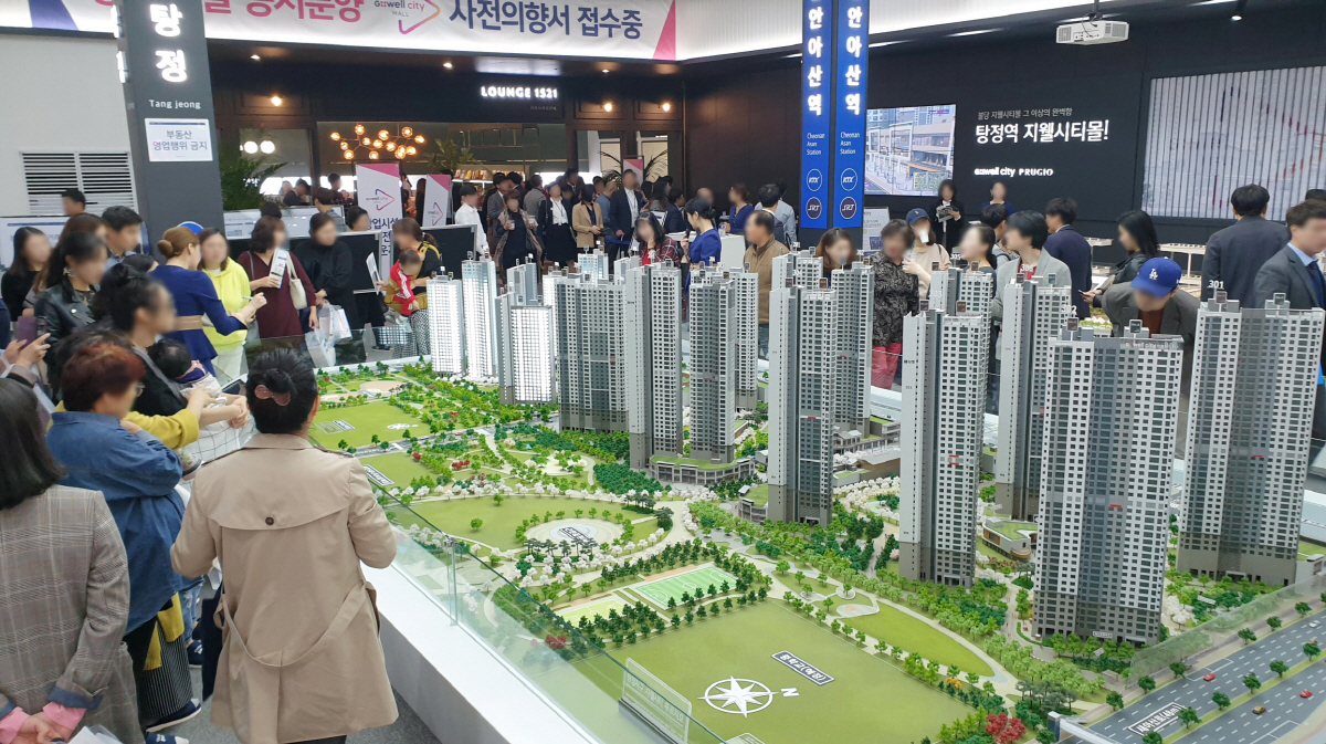 ▲‘탕정지구 지웰시티 푸르지오 2차’ 아파트 견본주택을 찾은 주택 수요자들이 단지 건물 모형을 살펴보고 있다. (사진 제공=신영)
