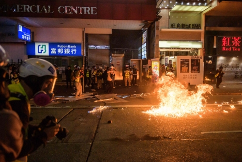 ▲홍콩 주말 시위에 참여한 시민들이 20일(현지시간) 코룬 지역에서 행진 도중 던진 화염병에 도로에 불이 붙었다. 홍콩/AFP연합뉴스 
