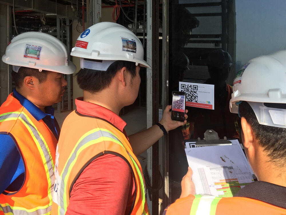 ▲두바이 로얄 아틀란티스 리조트 & 레지던스 현장 직원들이 건물 벽면에 부착된 QR코드를 통해 실시간 공사 현황을 확인하고 있다. (사진 제공=쌍용건설)