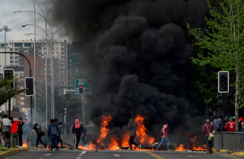 ▲지하철 요금 인상에 항의하는 칠레 시민들이 20일(현지시간) 도로에서 항의 시위를 벌이는 가운데 바이케이드에 불이 붙었다. 로이터연합뉴스 
