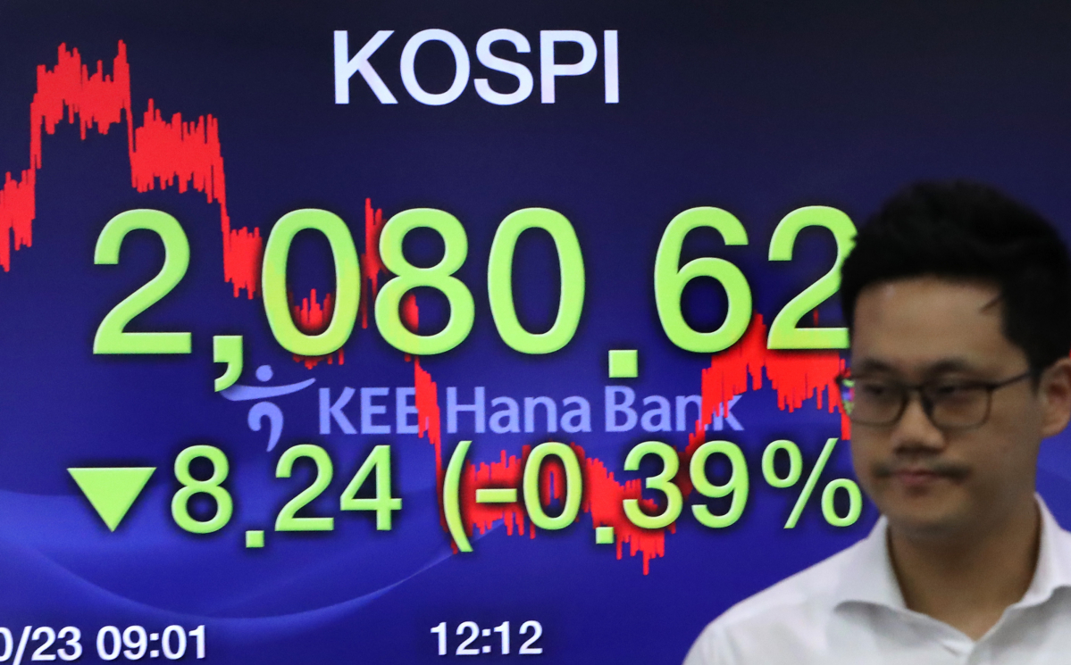 ▲코스피가 8.24포인트 하락한 2080.62로 장을 마감한 23일 서울 중구 KEB 하나은행 딜링룸에서 한 딜러가 전광판 앞을 지나고 있다. (연합뉴스)