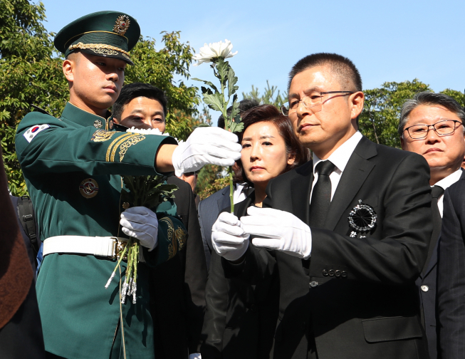 ▲자유한국당 황교안 대표와 나경원 원내대표가 26일 서울 동작구 국립서울현충원에서 열린 박정희 전 대통령 40주기 추도식에서 헌화를 위해 국화를 받고 있다.  (연합뉴스)