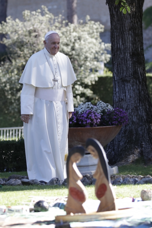 ▲프란치스코 교황이 지난4일 바티칸 정원에 세워진 임신한 여성 나무 조각상을 지나쳐 걸어가고 있다. 바티칸/APㅇ연합뉴스 
