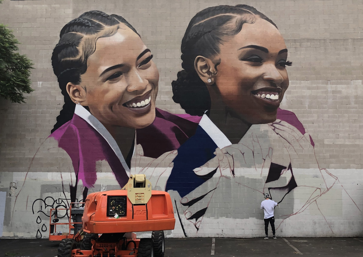 ▲로스엔젤레스 현지에서 심찬양 작가가 LG유플러스와 애플의 iPhone 11 Pro 공동 광고를 위해 DTLA 뮤직센터의 가로 30미터, 세로 15미터 규모 대형 벽면에 한복을 입은 외국인 여성의 모습을 직접 그리고 있는 모습. (사진제공=LG유플러스)