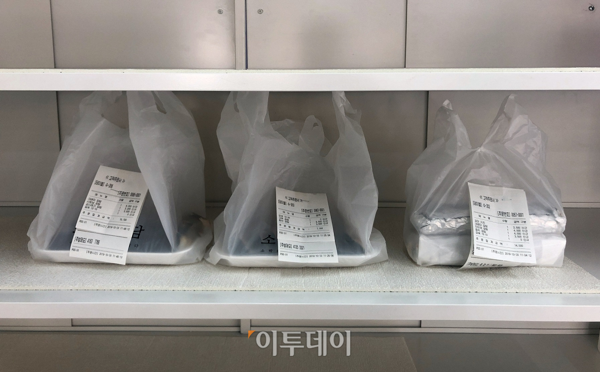 ▲전화주문 받은 음식은 곧바로 준비해 출구 바로 앞에 놓는다. 주문자는 음식에 붙어 있는 주문내역을 보고 자신의 것을 확인한 뒤 결제하고 음식을 수령하면 된다. (홍인석 기자 mystic@)