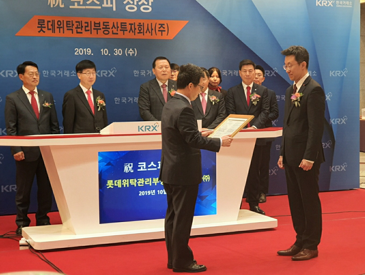 ▲지난 30일 한국거래소에서 열린 롯데리츠 상장 기념식에 참석한 정지원 한국거래소 이사장이 권준영 롯데AMC 대표이사에게 상장 기념패를 전달하고 있다.  (이다원 기자 @leedw)