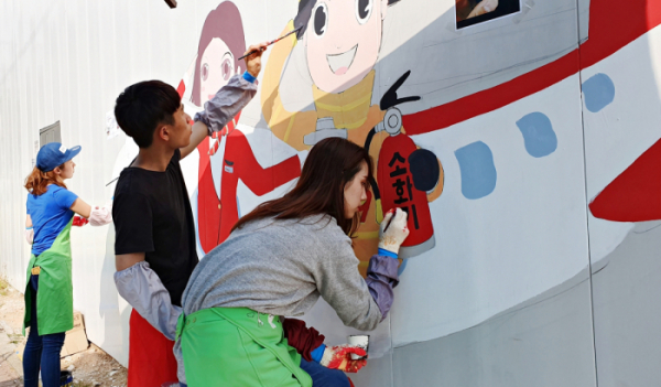 ▲티웨이항공 직원들이 금천구 소방서 공사 현장에서 벽화 그리기를 하고 있다.  (사진제공=티웨이항공)