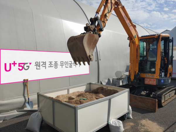 ▲성남 서울공항 전시장 밖에 마련된 작업장에서 5G 무인 굴삭기가 시연을 펼치는 모습 (사진제공=LG유플러스)