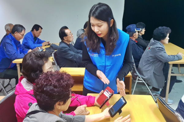 ▲어르신들이 18일 제주시 느영나영복지공동체에서 진행된 '스마트폰 보안교육'에서 우리은행 강사로부터 설명을 듣고 있다. (사진제공=우리은행)