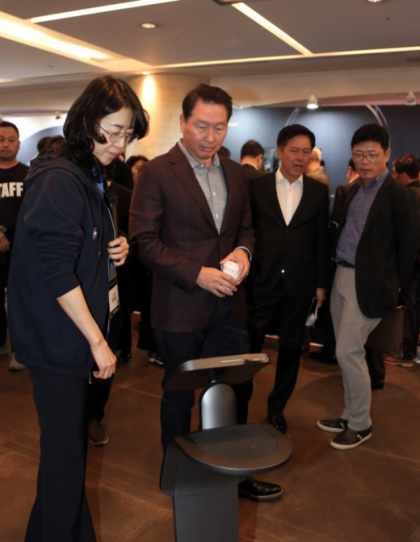 ▲최태원 SK 회장이 28일 서울 워커힐호텔에서 열린 'SK ICT Tech Summit 2019'에 참석해 SK텔레콤 인공지능 서비스 '누구'를 탑재한 퍼스널 로봇에 대한 설명을 듣고 있다. (사진제공=SK텔레콤)