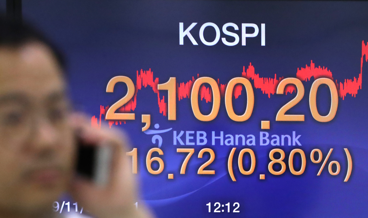 ▲코스피가 16.72포인트 오른 2100.20으로 장을 마감한 1일 서울 중구 KEB 하나은행 딜링룸에서 한 딜러가 전광판 앞을 지나고 있다.  (연합뉴스)