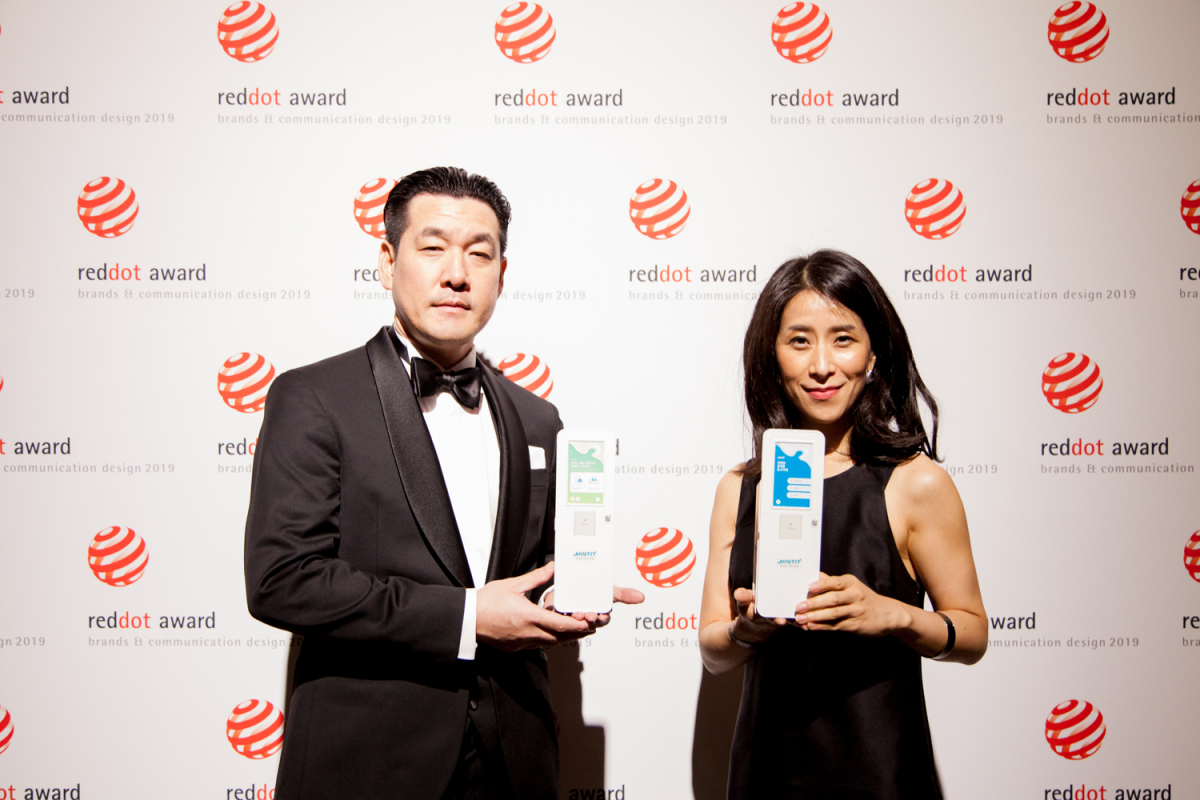 ▲김지은(오른쪽) SK네트웍스 ICT마케팅팀장이 1일 독일 베를린에서 열린 '2019 레드닷 디자인 어워드'에서 수상한 뒤 기념사진을 찍고 있다. (사진제공=SK네트웍스)