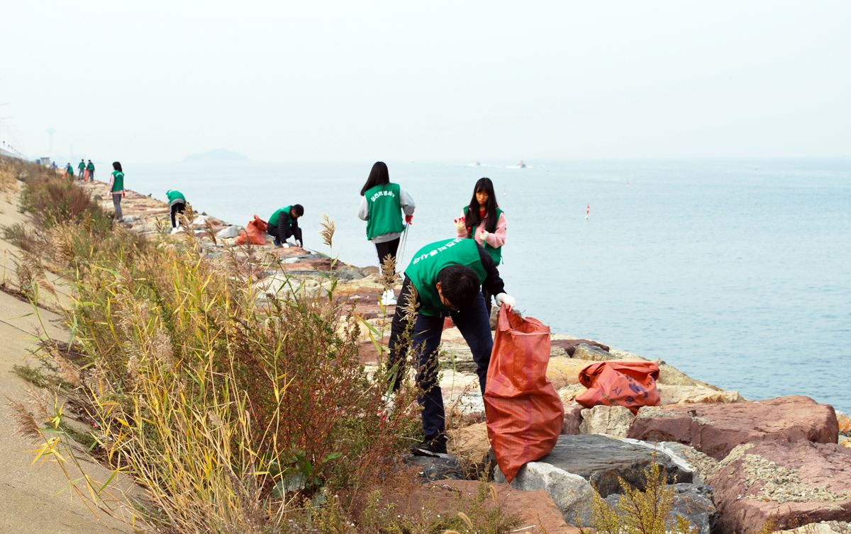 ▲삼천리 임직원과 가족 봉사자들이 시화방조제에서 환경정화활동을 펼치고 있다. (사진제공=삼천리)