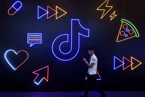 ▲2016년 바이트댄스가 출시한 동영상 공유 애플리케이션 딕톡의 로고 앞을 시민이 지나가고 있다. 항저우/로이터연합뉴스 
