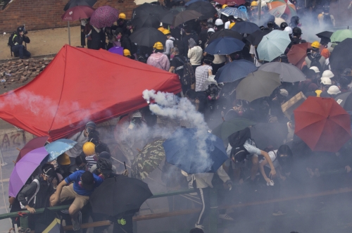 ▲홍콩이공대에 포위된 시위대가 18일(현지시간) 경찰 저지선을 뚫고 탈출하려다 경찰이 쏜 최루탄에 안으로 도망가고 있다. 홍콩/AP연합뉴스 
