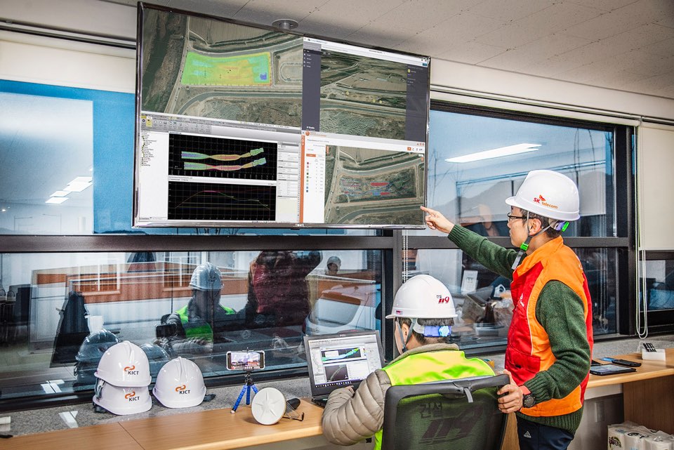 ▲SK텔레콤은 한국건설기술연구원, 트림블(Trimble), 현대건설기계, SK건설 등과 함께 SOC 실증연구센터에서 ICT를 활용한 도로공사 실증을 성공리에 마쳤다고 21일 밝혔다. 사진은 엔지니어들이 SOC실증연구센터에서 스마트 건설 방식으로 공사를 진행하고 있는 모습. (사진제공=KT)
