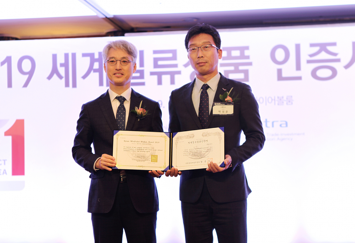 ▲권오혁(오른쪽) 휴비스 R&D센터 그룹장이 '2019 세계일류상품 선정기업 인증 수여식’에서 산조영신 업통상자원부 중견기업정책관 국장과 기념사진을 찍고 있다. (사진제공=휴비스)