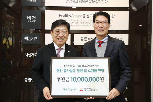 ▲박재식 저축은행중앙회장(왼쪽)이 27일 시립마포노인종합복지관에 후원금을 전달하고 기념촬영을 하고 있다.  (사진 제공=저축은행중앙회)