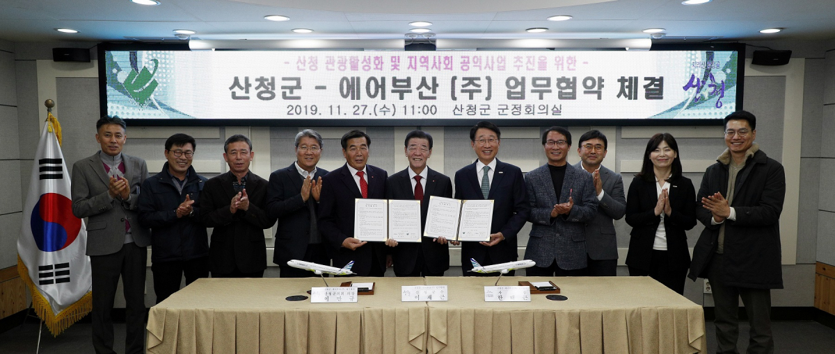 ▲한태근 에어부산 사장(왼쪽 7번째)과 이재근 산청 군수(왼쪽 6번째)를 비롯한 관계자들이 업무 협약을 체결 후 기념 촬영을 하고 있다.  (사진제공=에어부산)