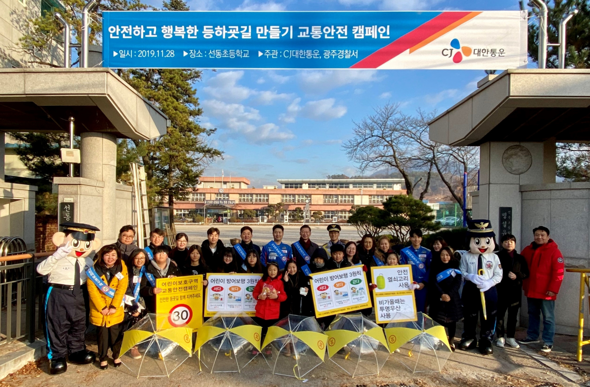▲CJ대한통운은 28일 경기도 광주선동초등학교에서 등굣길 아동에게 투명 안전우산을 나눠주고 운전자를 대상으로 스쿨존 교통안전캠페인을 진행했다. 이날 행사에는 CJ대한통운 임직원들과 경기 광주경찰서, 선동초등학교 학부모회 등이 참여했다.  (사진제공=CJ대한통운)