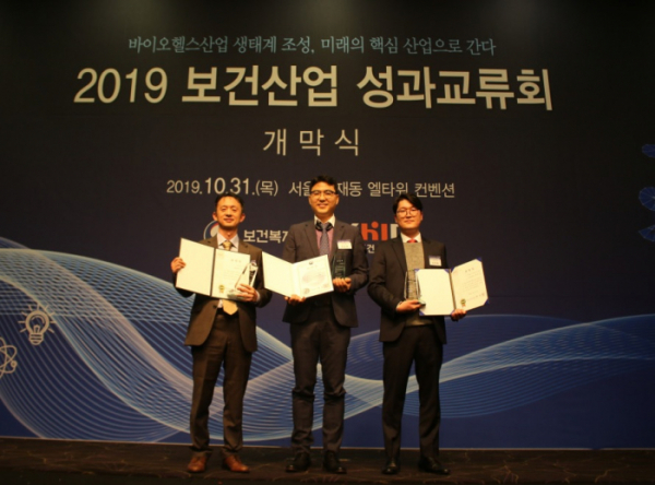 ▲대웅제약이 31일 ‘2019 보건산업 성과 교류회에서’ 우수 혁신형 제약기업으로 선정돼 보건복지부장관상과 한국보건산업진흥원장상을 수상한 후 전승호 대표(가운데)와 박성수 나보타사업본부장(왼쪽), 조민재 팀장(오른쪽)이 기념사진을 촬영하고 있다. (사진제공=대웅제약)