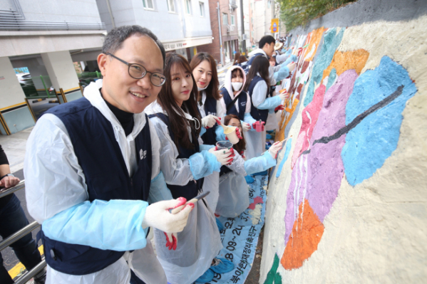 ▲OK금융그룹 임직원이 지난 2일 서울 양동초등학교에서 벽화 그리기 봉사활동을 하고 있다. (사진 제공=OK금융그룹)