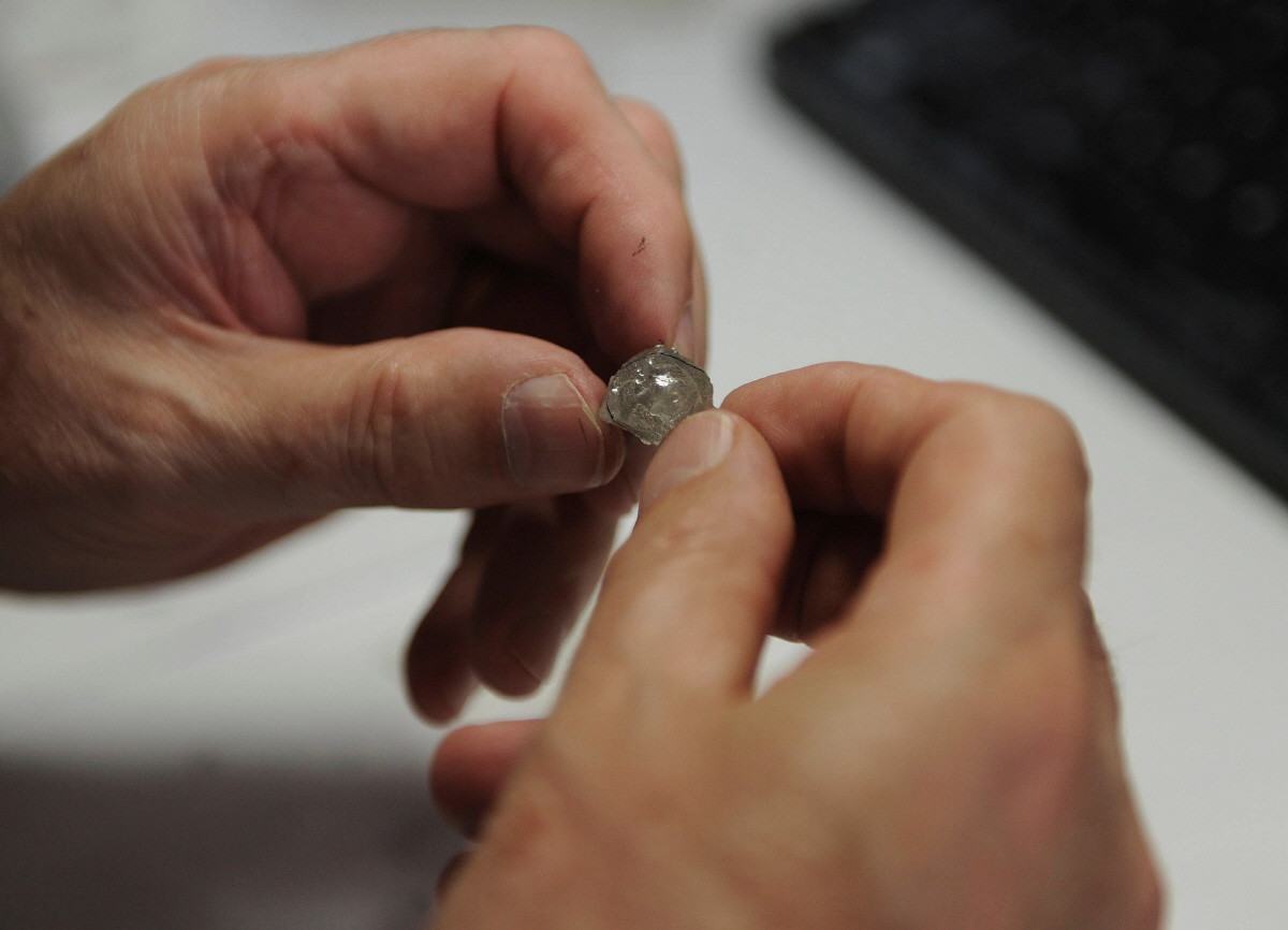 ▲세계 최대 다이아몬드 광산업체 드비어스(De Beers)의 직원이 보츠와나 가보로네에 있는 드비어스 사무실에서 광산에서 캐낸 다이아몬드를 평가하고 있다. 가보로네/AFP연합뉴스.