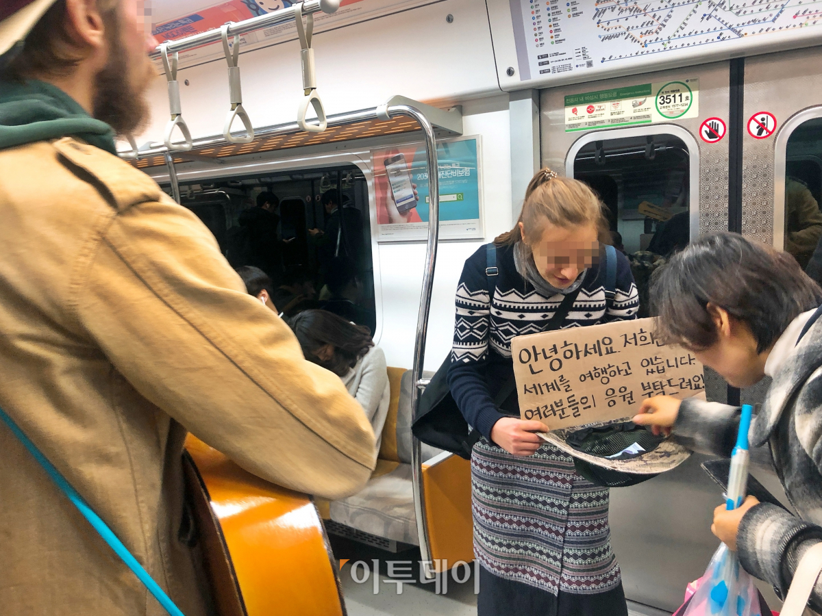 ▲한 시민이 베그패커가 들고 있는 모자에 1000원을 넣었다. 1~2명의 시민이 돈을 보탰다.  (홍인석 기자 mystic@)